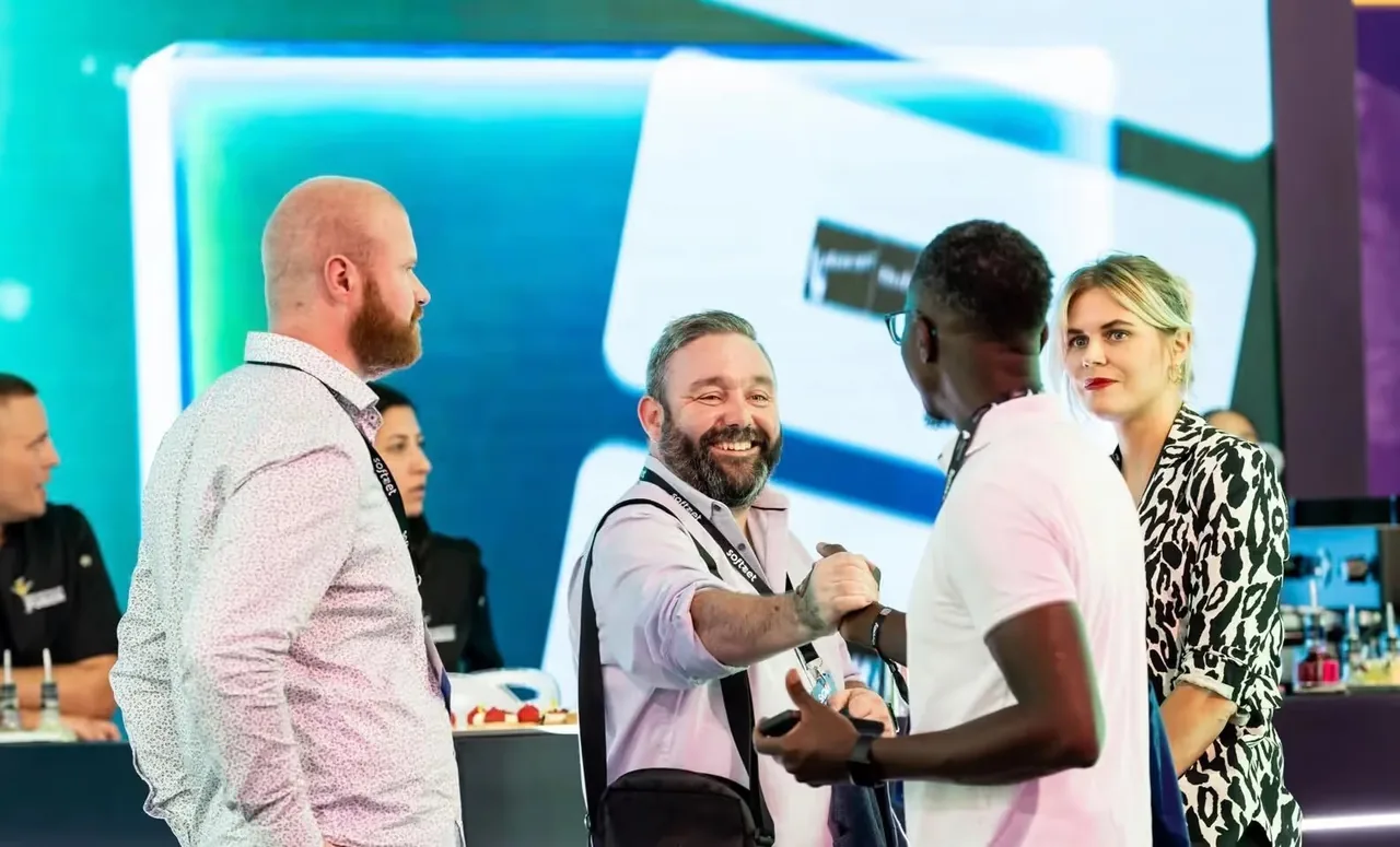 Professionals greeting each other at the Soft2Bet stand during an industry expo